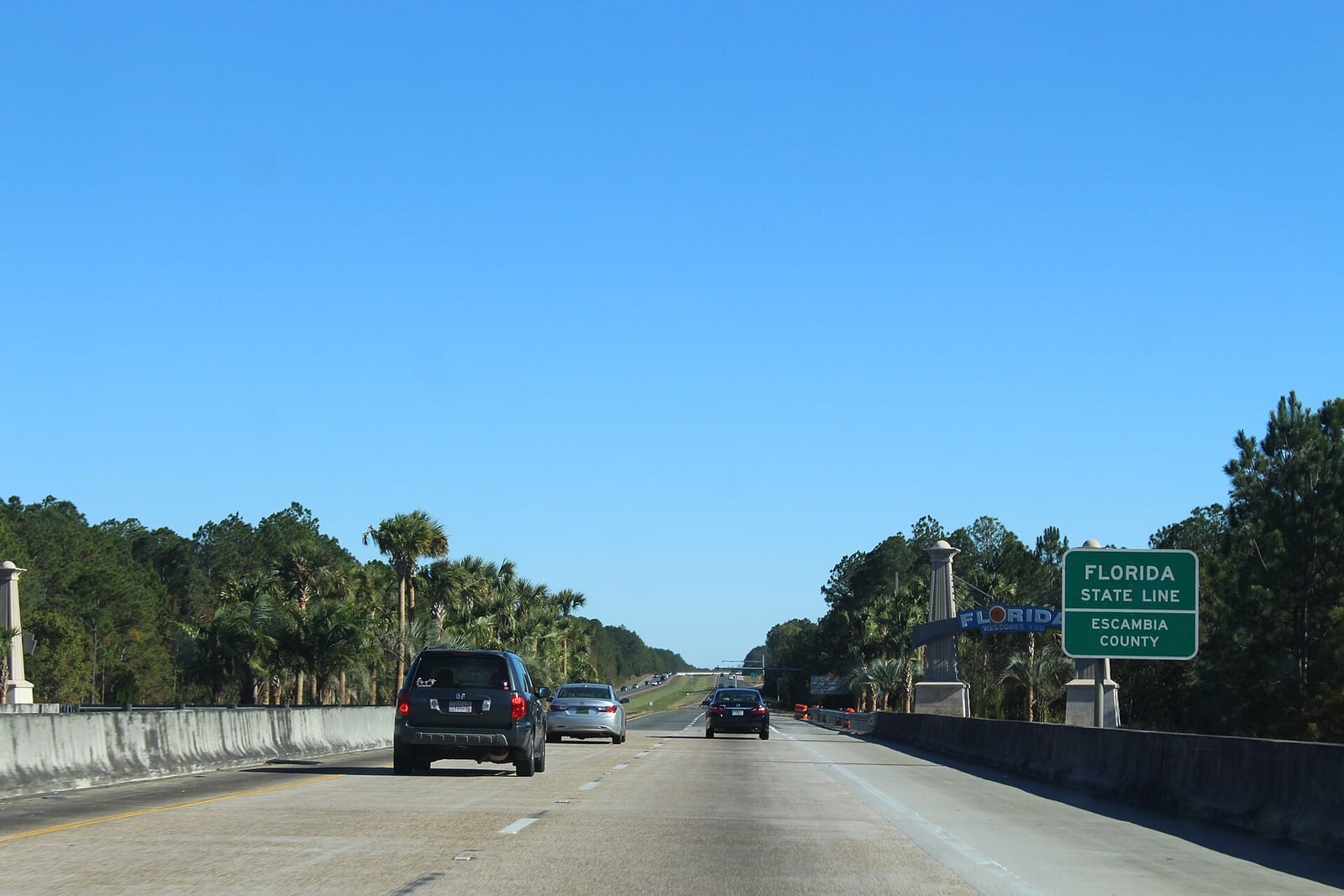 Interstate 10 eastbound at the Florida state line sign for Escambia County with the Florida welcomes you sign beside the highway