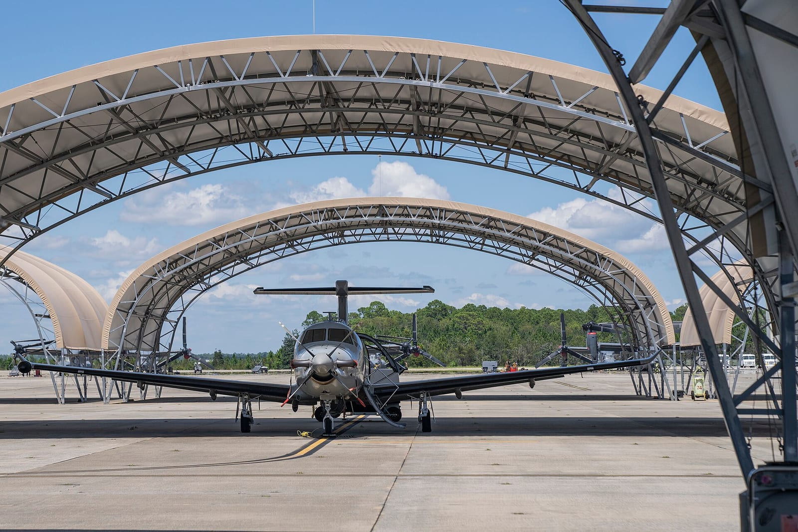 A U-28A Draco aircraft parked under a shade hangar on the Hurlburt Field flightline, Florida