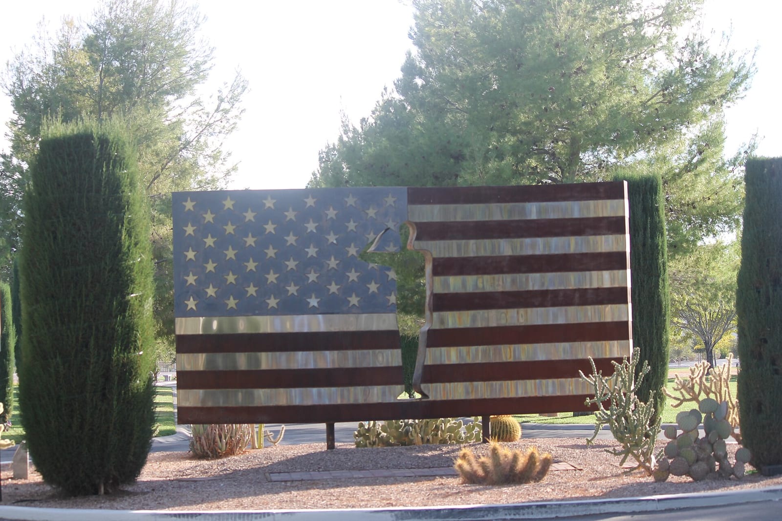 Steel American flag sculpture with the silhouette of a saluting service member at a veterans memorial