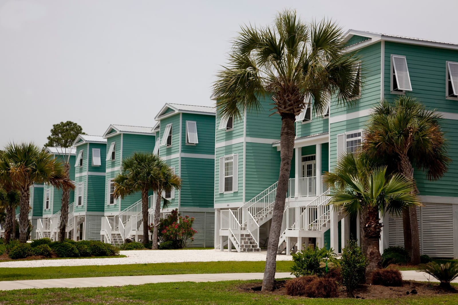 Archival photograph of raised coastal homes and palm trees in Gulf Shores, Alabama