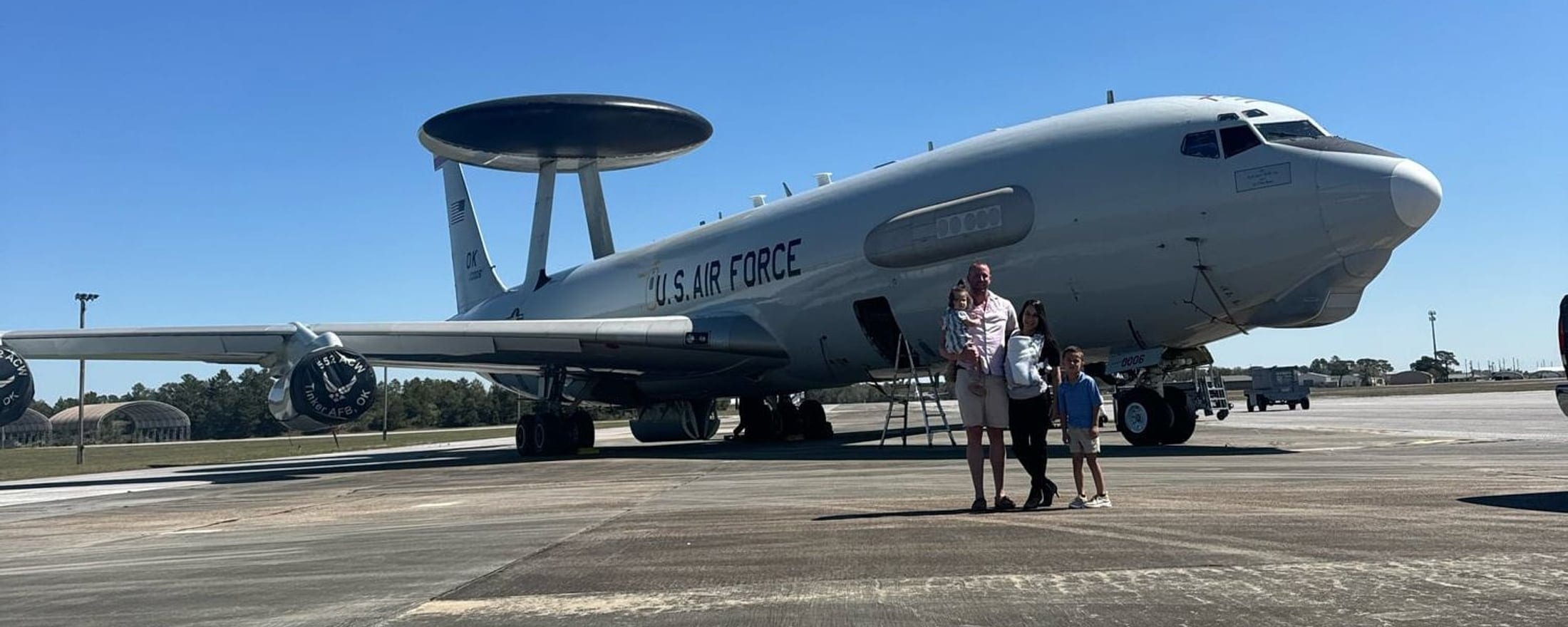 A military family on the flightline beside an E-3 AWACS